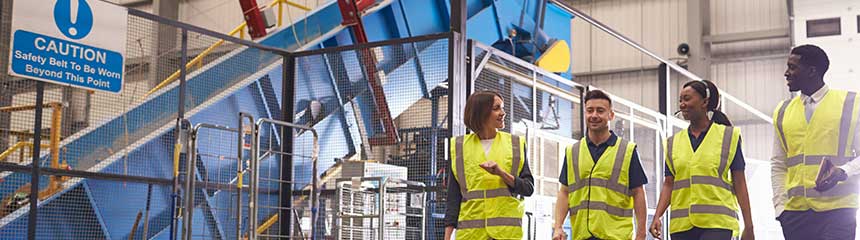 Staff wearing reflective vests in an industrial interior